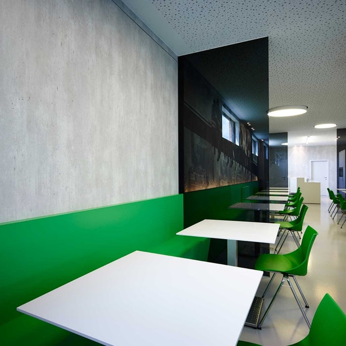 Modern interior with green walls, white tables, and green chairs.