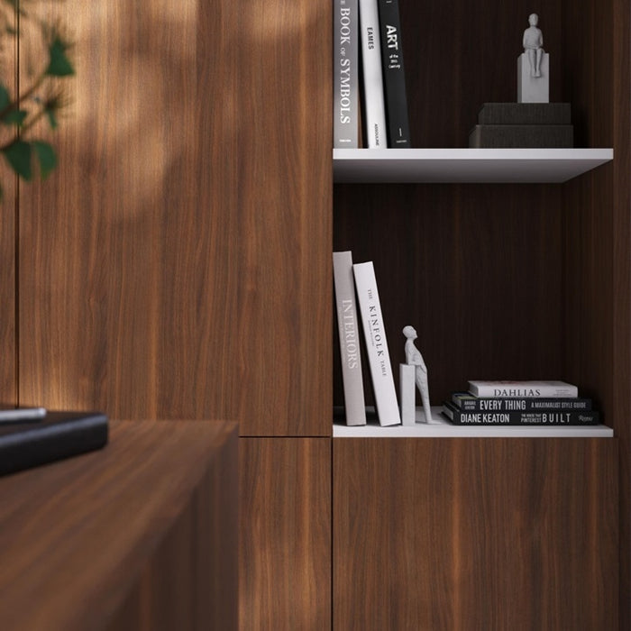 Wooden bookshelf with books and a statue on a white shelf.