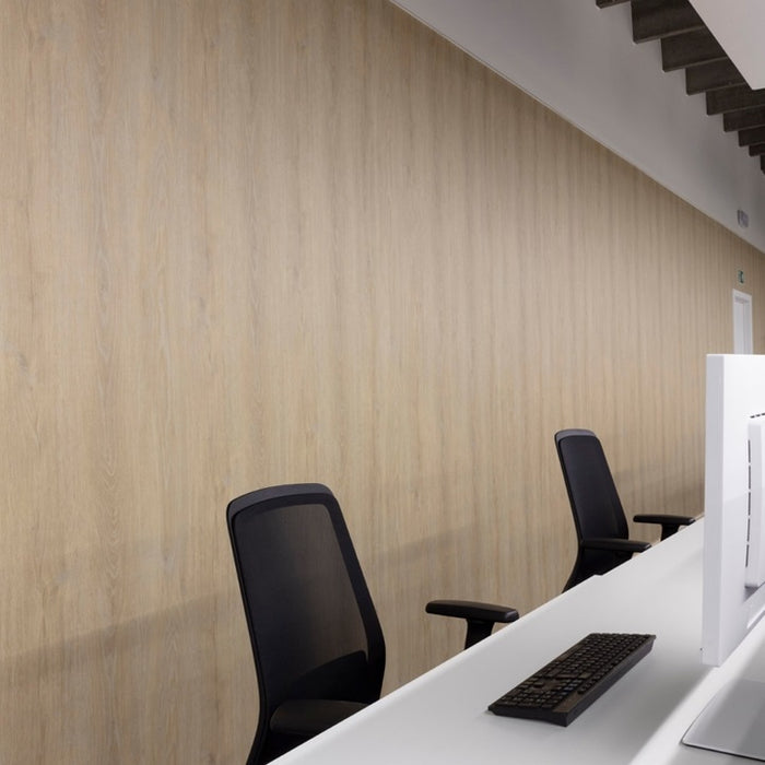 Modern office setup with a desk, chair, and computer monitor against a beige wall.