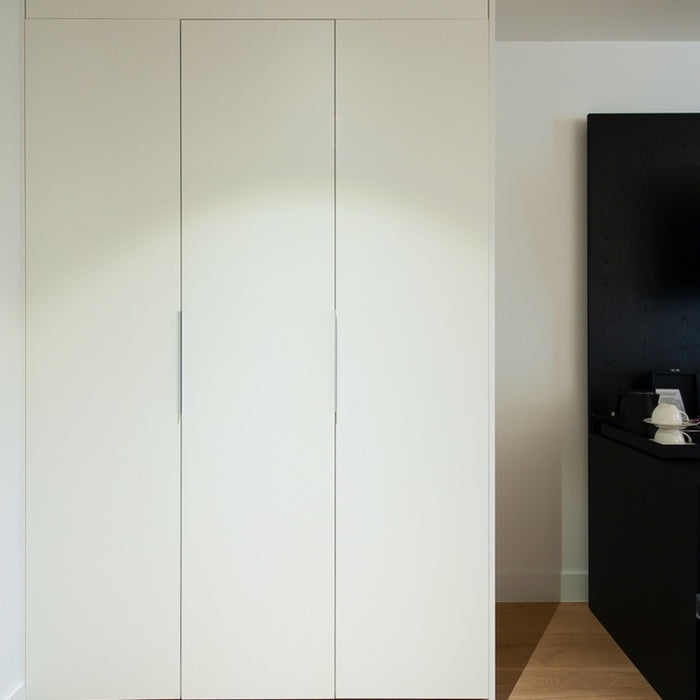 White wardrobe with a black television on a stand in the background