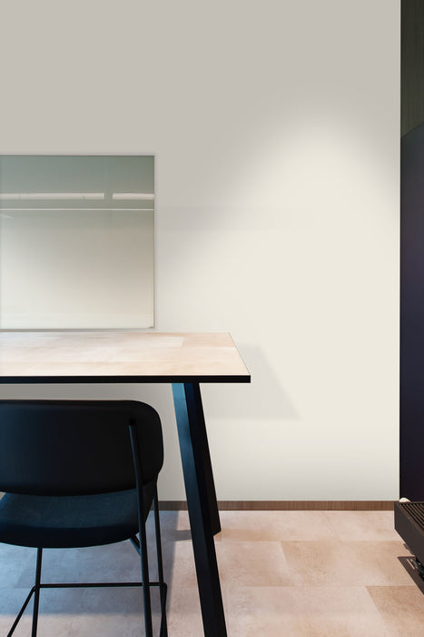 Minimalist desk setup with a chair against a white wall.